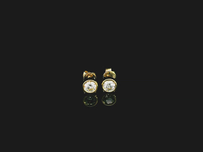 18K yellow gold bezel-set diamond stud earrings with round brilliant diamonds.