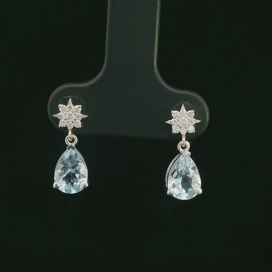 18K white gold aquamarine and diamond drop earrings featuring pear-cut aquamarine gemstones (1.08 CT total) and a brilliant diamond cluster (0.11 CT total), set in a classic drop design.