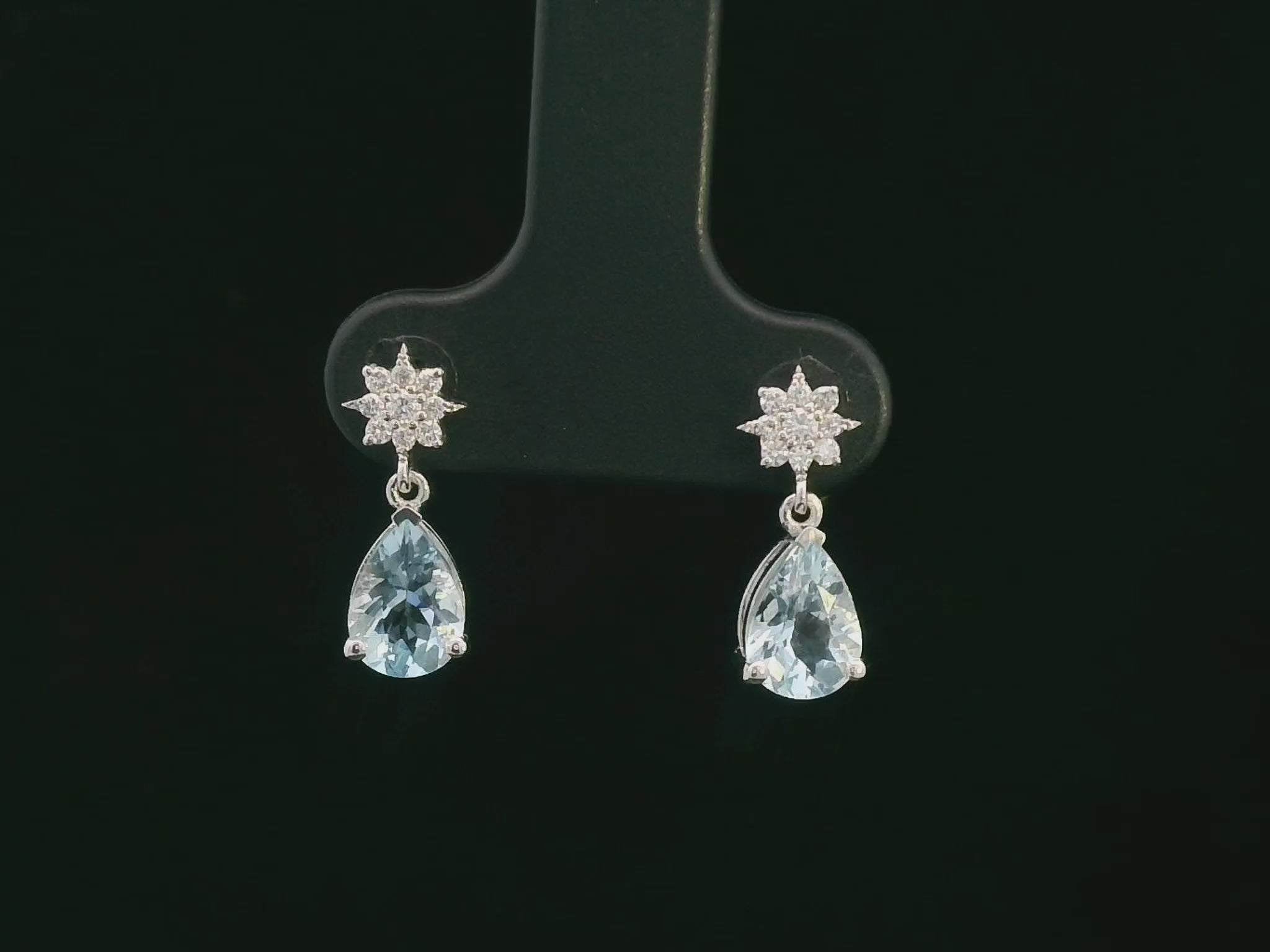 18K white gold aquamarine and diamond drop earrings featuring pear-cut aquamarine gemstones (1.08 CT total) and a brilliant diamond cluster (0.11 CT total), set in a classic drop design.