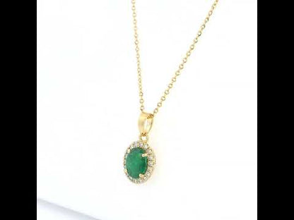 Oval emerald and diamond halo pendant in 18K yellow gold featuring a 1.30 carat green emerald surrounded by round diamonds totalling 0.23 carat. 