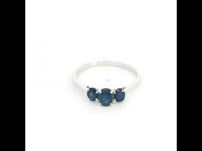 18K white gold ring featuring three oval blue sapphires, with a larger centre gemstone and two smaller side stones on a slim polished band.