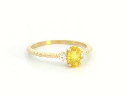 18K gold ring with oval yellow sapphire, side diamonds, and textured beaded band 