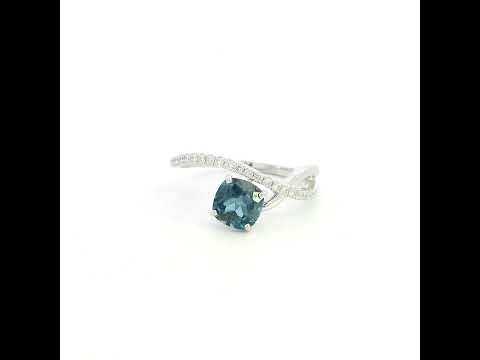 18K white gold twist ring featuring a 1.10 carat natural cushion-cut London Blue Topaz with a diamond-set crossover band and 0.15 carat natural diamonds.