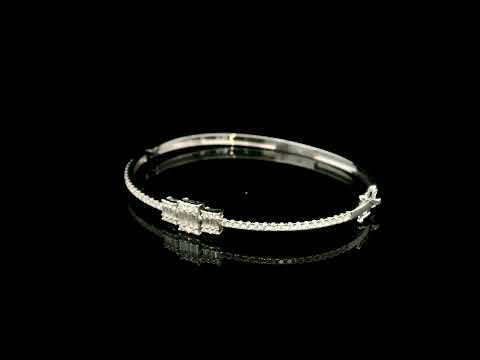 Baguette and round diamond bangle in 18K white gold with three geometric diamond centre motifs.