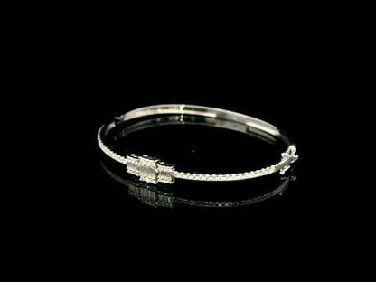 Baguette and round diamond bangle in 18K white gold with three geometric diamond centre motifs.