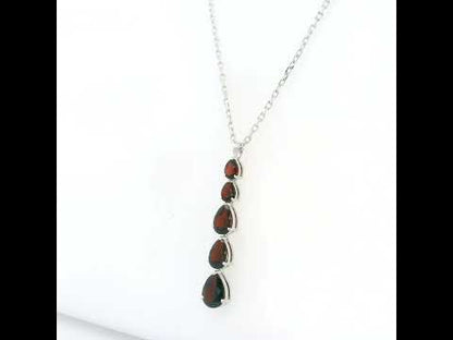 Pear shaped garnet drop pendant in 18K white gold featuring five graduated deep red garnets totalling 2.26 carat, arranged vertically in delicate prong settings. Chain  sold separately 