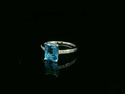 Swiss blue topaz emerald cut ring with diamond band in 18K white gold by Emirates Diamonds