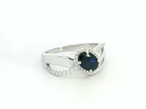 18K white gold blue sapphire and diamond bypass ring with oval sapphire and halo, 0.77 carat sapphire and 0.25 carat total diamond weight, fine jewelry by Emirates Diamonds