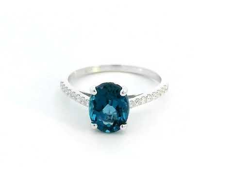 Elegant 18K white gold ring with a 2.48-carat oval London blue topaz center stone and a 0.16-carat diamond-accented band.