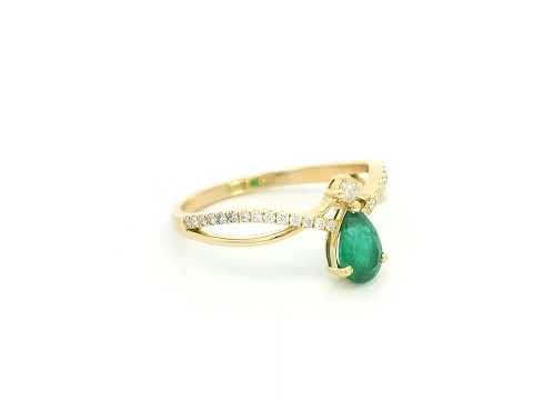 Pear shaped emerald and diamond crossover ring in 18K yellow gold