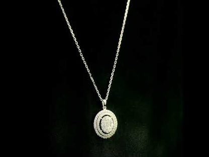 Oval diamond cluster pendant in 18K white gold with a central round diamond cluster and two diamond-set oval surrounds.