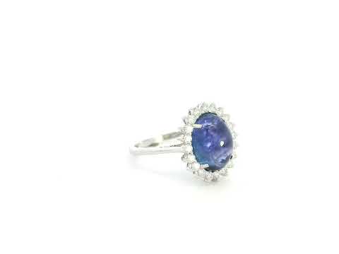 Cabochon tanzanite diamond halo ring in 18K white gold with oval blue tanzanite