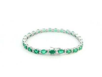 18K white gold tennis bracelet with 8.88ct oval-cut emeralds and 0.80ct diamond accents.