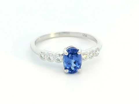 Oval tanzanite and diamond ring in 18K white gold with bezel-set side stones