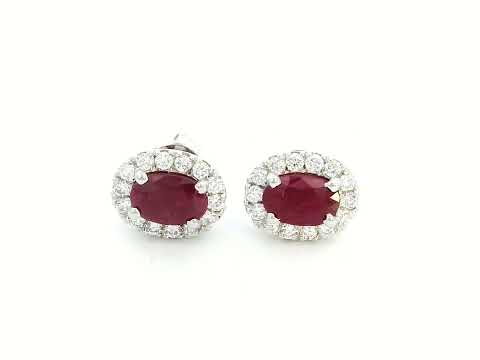 White gold earrings with oval rubies (1.52 CT) and a halo of sparkling diamonds (0.33 CT). Classic and elegant fine jewelry.