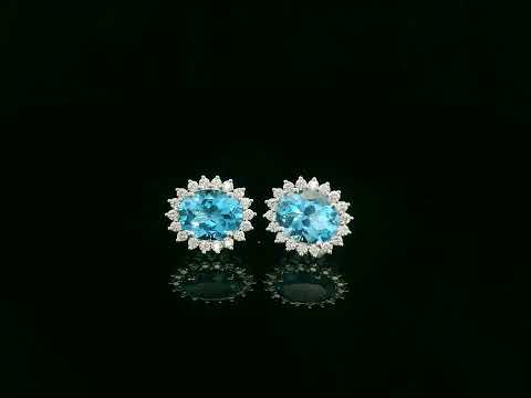18K white gold stud earrings featuring oval Swiss blue topaz gemstones surrounded by diamond halos