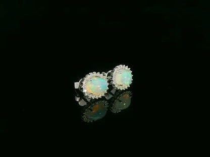 Opal and diamond halo stud earrings in 18K white gold by Emirates Diamonds.