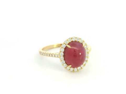 18K yellow gold ruby cabochon halo ring featuring a 4.17 carat natural oval ruby surrounded by 0.33 carat natural diamonds.