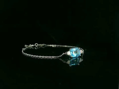 18K white gold Swiss blue topaz bracelet with emerald-cut center stone and diamond accents – Emirates Diamonds