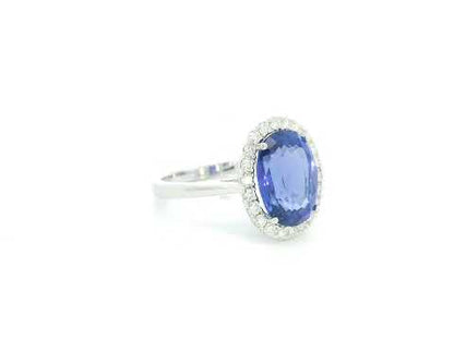 18K white gold halo ring featuring a 4.95 carat oval tanzanite surrounded by 0.37 carat natural diamonds.
