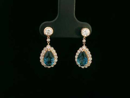 Elegant 18K gold pear-cut London blue topaz and diamond halo drop earrings featuring 2.00 carats of topaz and 0.66 carats of diamonds.