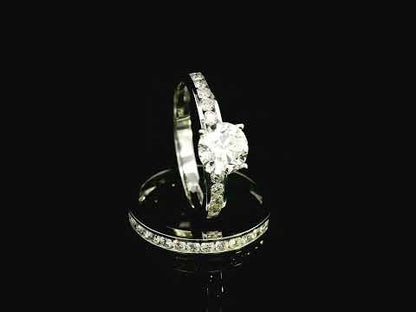 18K white gold bridal set with a 1.00-carat SI2, H-color center diamond, featuring channel-set accent diamonds totaling 0.72 carats on the engagement ring and wedding band