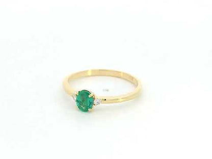 Dainty oval emerald and diamond ring in 18K yellow gold by Emirates Diamonds