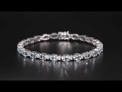 Aquamarine tennis bracelet in 18K white gold featuring oval blue aquamarine gemstones and sparkling diamond accents.