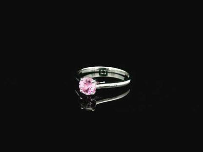 18K white gold pink sapphire solitaire ring featuring a 0.91 carat round pink sapphire in a classic four-prong setting