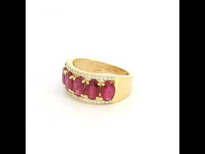 Oval ruby and diamond band ring in 18K yellow gold with a row of rubies framed by round diamonds.