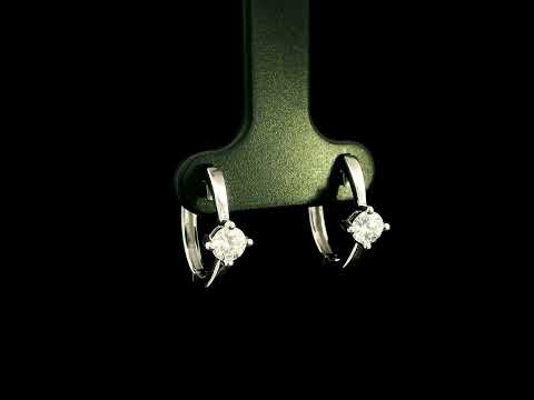 18K white gold huggie hoop earrings featuring a round diamond in a four-prong setting on each polished hoop.