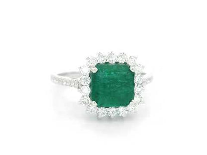 Emerald and diamond halo ring in 18K white gold featuring a 2.12 carat emerald and pavé diamond band by Emirates Diamonds
