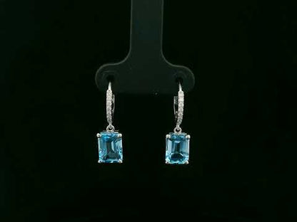 18K white gold hoop drop earrings featuring emerald-cut Swiss Blue Topaz and diamond accents by Emirates Diamonds.