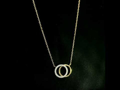 Interlocking diamond circle necklace in 18K yellow gold with one diamond-set circle and one polished gold circle.