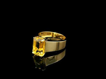 Men's yellow beryl ring in 18K yellow gold featuring a rectangular emerald-cut gemstone in a four-prong setting and a wide gold band.