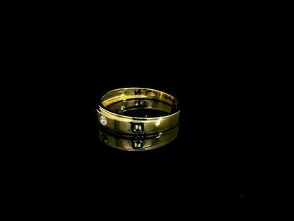 Men's 18K yellow gold band featuring a single round flush-set diamond, polished finish and fine grooved detailing.