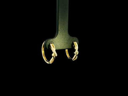 Diamond twist hoop earrings in 18K yellow gold with intertwined polished gold and round brilliant diamond details.