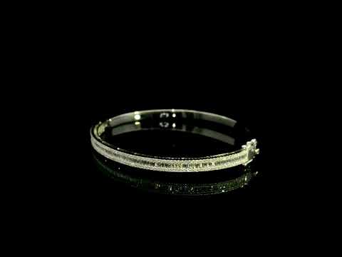 18K white gold diamond bangle with a central row of baguette diamonds framed by round brilliant diamonds and secure hinged clasp