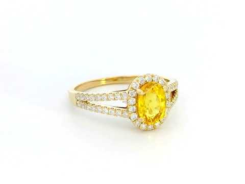 Yellow sapphire and diamond halo ring in 18K yellow gold featuring a 1.21-carat oval yellow sapphire, surrounded by a diamond halo and a split band adorned with diamonds, totaling 0.35 carats, with a smooth polished gold finish