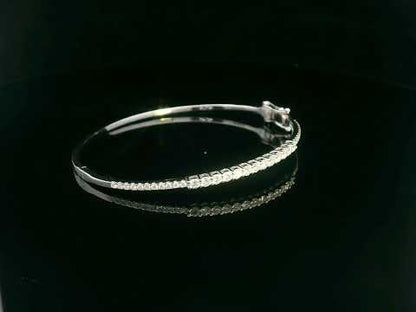 Minimalist 18K gold bangle with 1.03 carat dual-size round-cut diamonds, polished finish