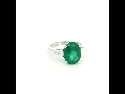 Natural oval emerald and tapered baguette diamond three stone ring in 18K white gold with a 4.03 carat centre emerald.