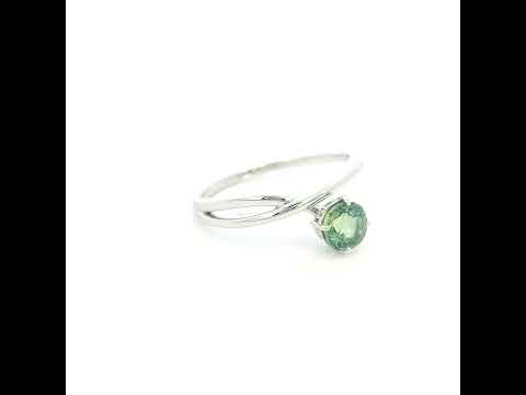 18K white gold crossover ring featuring a natural 0.88 carat round green sapphire in a contemporary solitaire design.