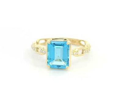 Emerald-cut Swiss blue topaz and diamond ring in 18K yellow gold by Emirates Diamonds.