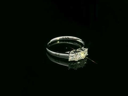 18k white gold trilogy ring with three princess-cut diamonds, total 0.66 ct, modern classic design.