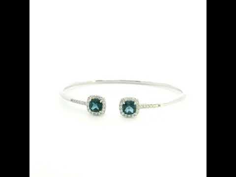 London Blue Topaz and diamond open bangle in 18K white gold with two cushion-cut blue topaz gemstones and diamond surrounds
