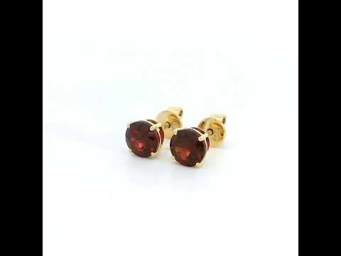 Round garnet solitaire stud earrings in 18K yellow gold with classic four-prong settings by Emirates Diamonds.