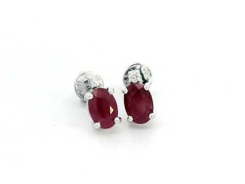 18K white gold earrings featuring a 1.31 carat oval ruby accented by 0.04 carats of diamonds, perfect July birthstone jewelry