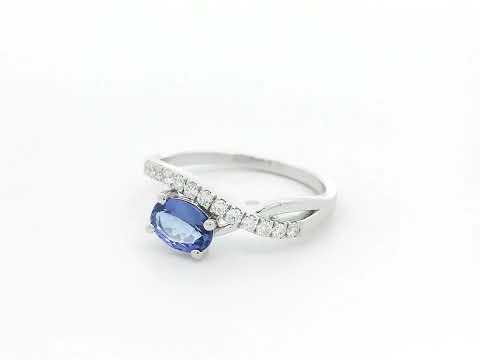 18K white gold tanzanite ring featuring a 0.70 carat oval-cut tanzanite and 0.23 carats of natural diamonds in a crossover design.