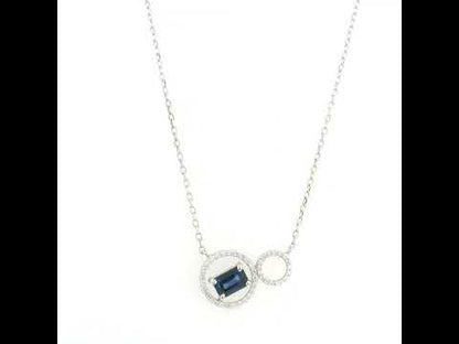 Blue emerald-cut sapphire and diamond necklace in 18K white gold, featuring an asymmetrical double-circle design with round diamond accents.