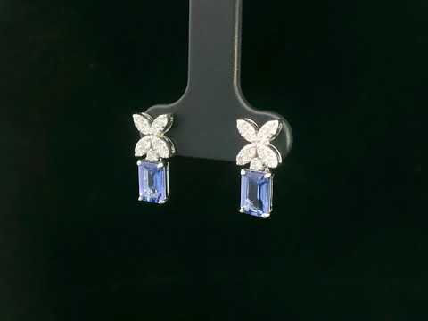 18K white gold earrings featuring emerald-cut Tanzanites beneath floral diamond clusters, total 1.56 carat